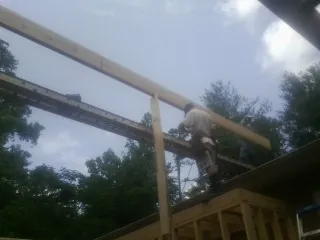 Carpenter setting a ridge beam over a new addition frame — Ice Dam Removal by Roofing Brothers in Jackpot