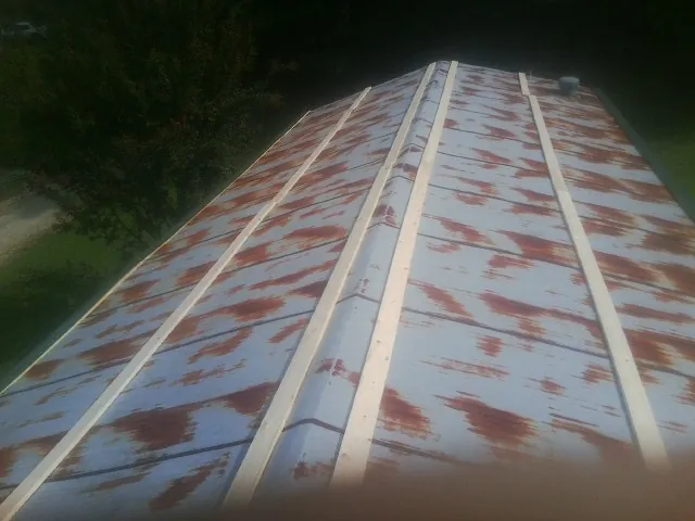 Rusted metal roof panels with new wood purlins before replacement — Storm Damage Roof Repair in Jackpot by Roofing Brothers
