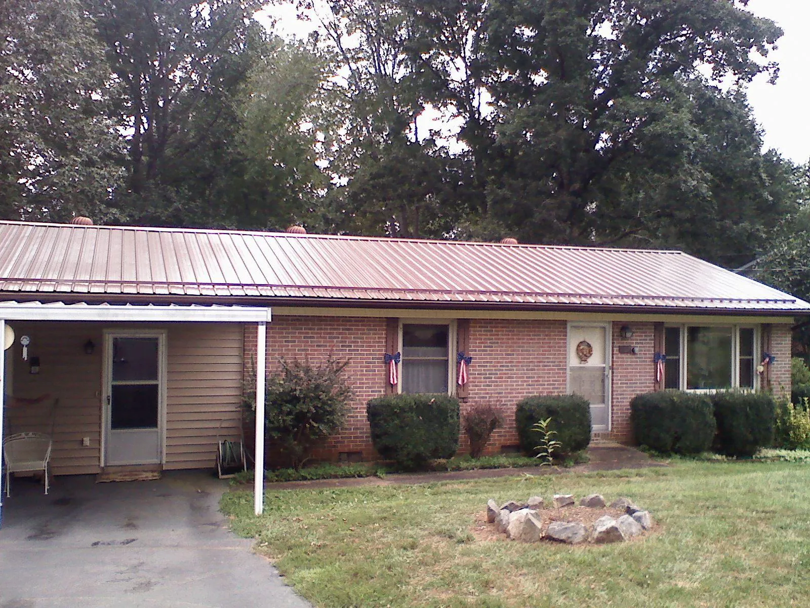 Bronze metal roof and carport on a brick ranch home — Roof Repair work by our crew in Jackpot
